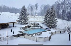 Enjoy a refreshing swim in the outdoor pool, surrounded by lounge chairs and trees.