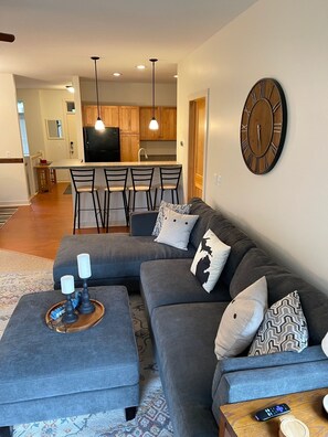 Relax in this stylish living room with a comfortable sofa, coffee table, and kitchen area.