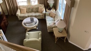 A living room with a sofa, armchair, coffee table, and lamps. - Desired Resort on Hilton Head Island (3 BD, 3BA Condo near beach) (Hilton Head)