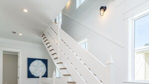 A staircase with white railings and wooden steps, leading to a second floor. - Southern Sand: beach house with beautiful forest views (Santa Rosa Beach)