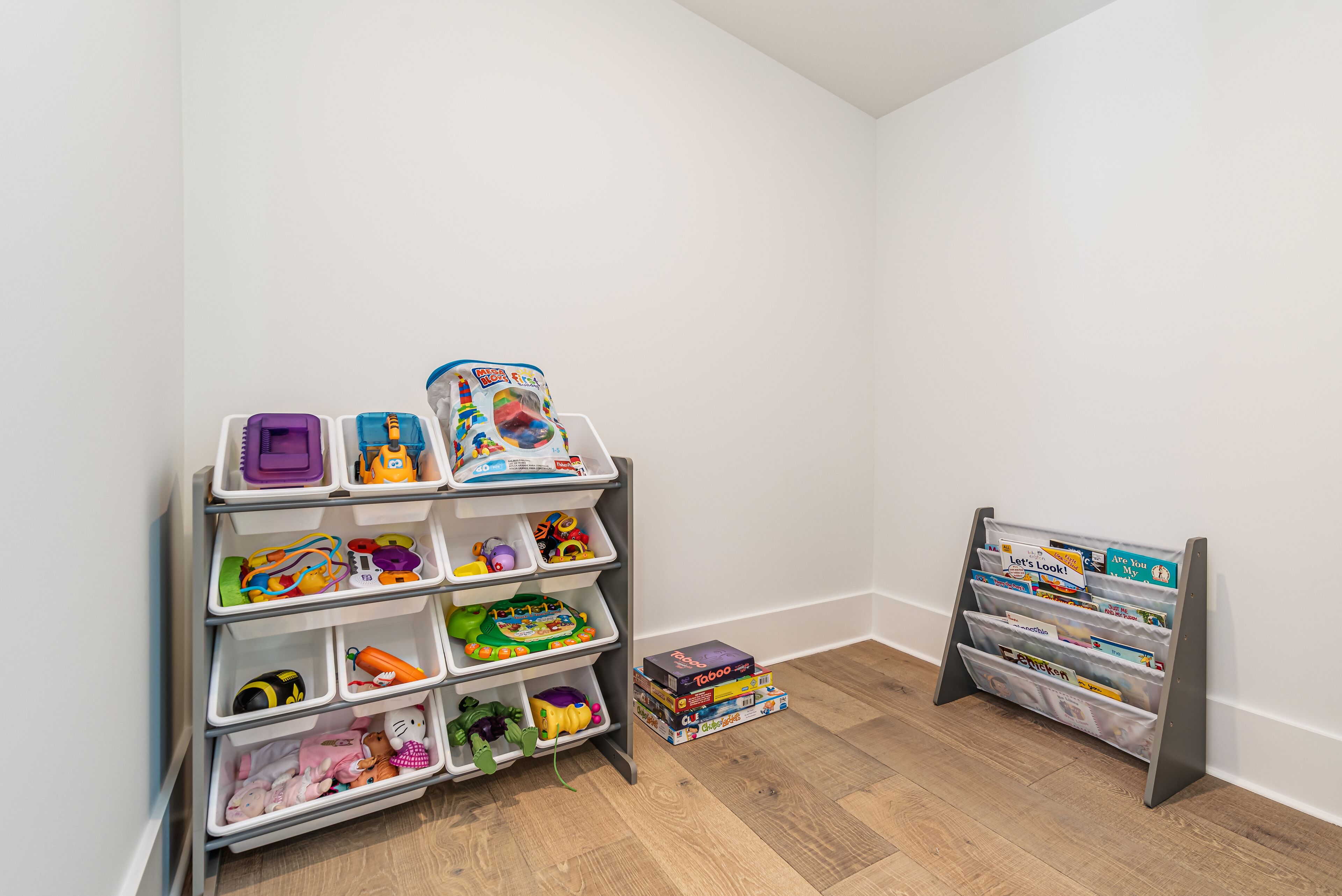 Un espace de rangement doté de plusieurs compartiments contenant des jouets et des jeux.