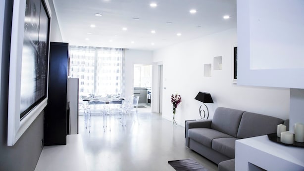 Un salon moderne avec un canapé gris, une table basse et un téléviseur posé sur un meuble.
