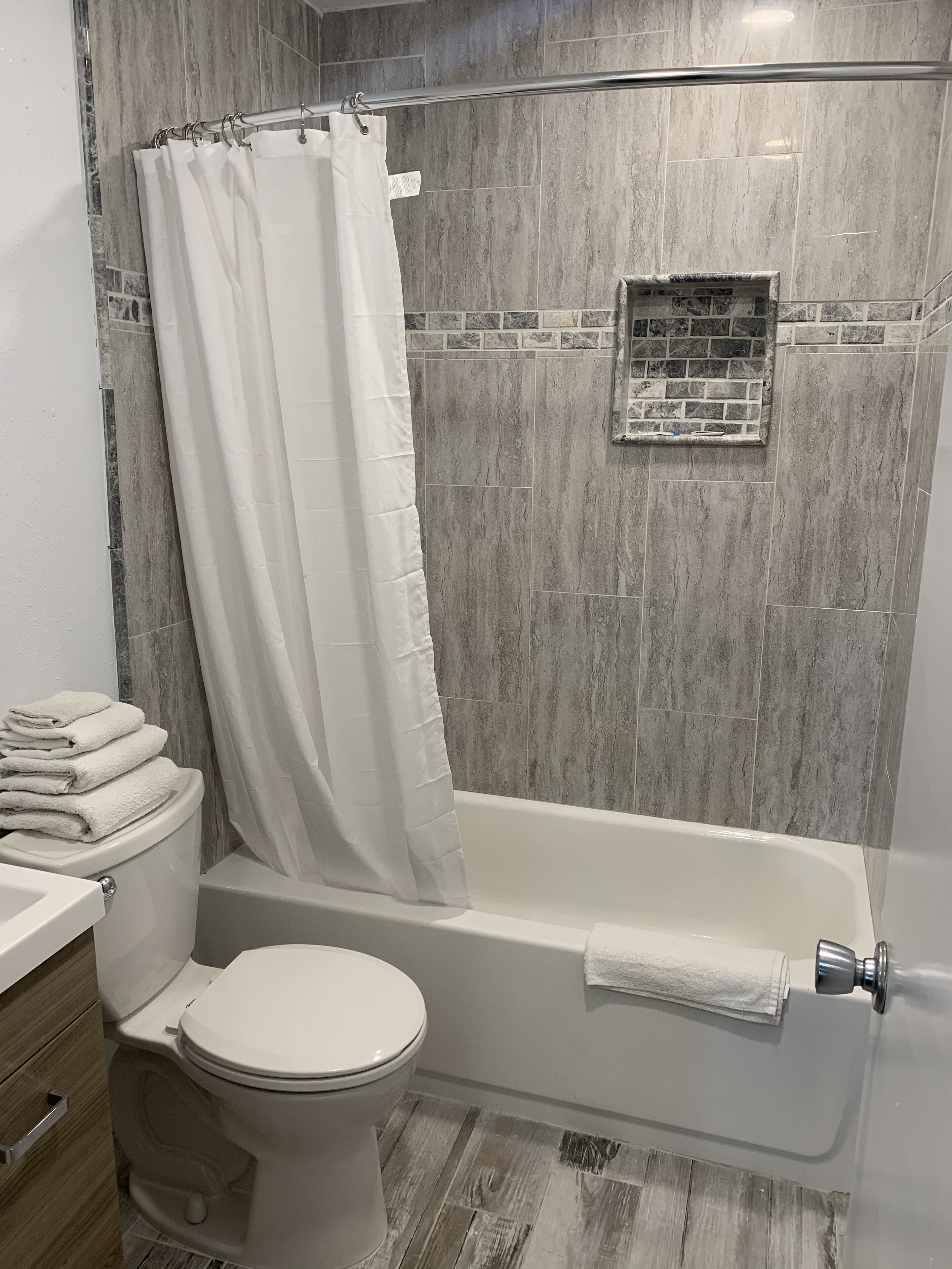 A bathroom with a shower, toilet, and sink.