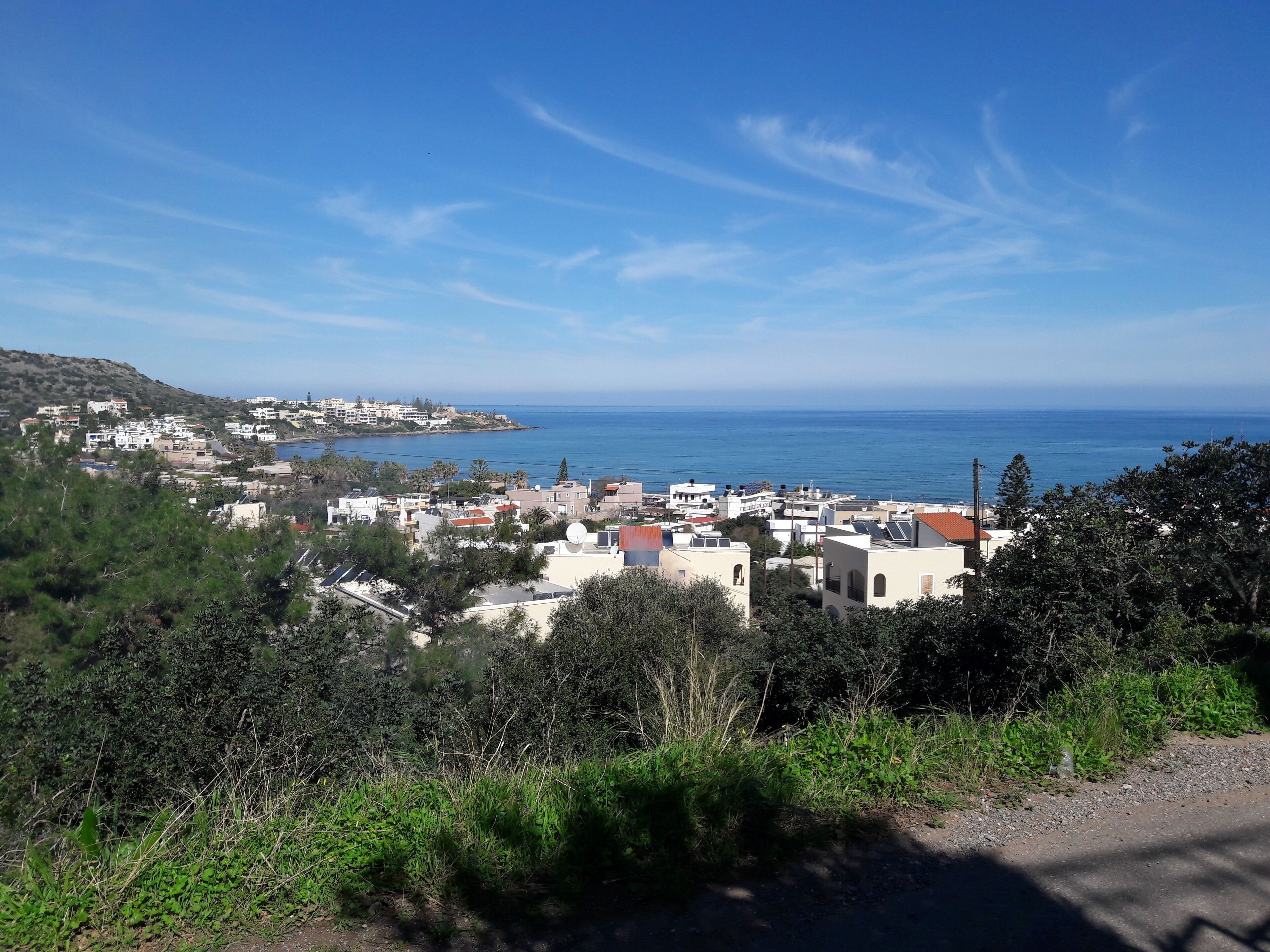 Une ville côtière avec des bâtiments, une route et une vue sur la mer.