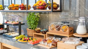 Een ontbijtbuffet met fruit, yoghurt en ontbijtgranen.