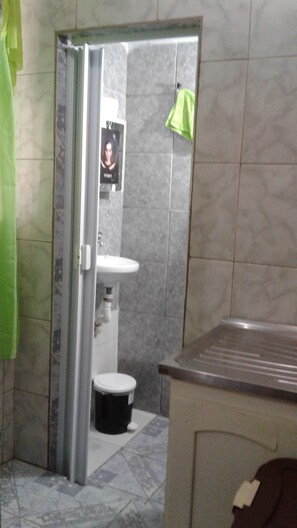 Een douche, een bidet, handdoeken, toiletpapier