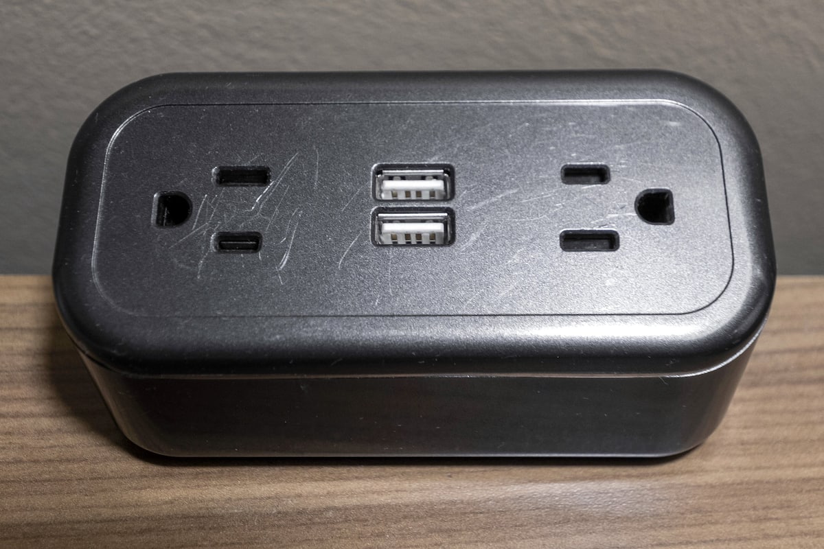 A black power strip with two USB ports and two standard electrical outlets.