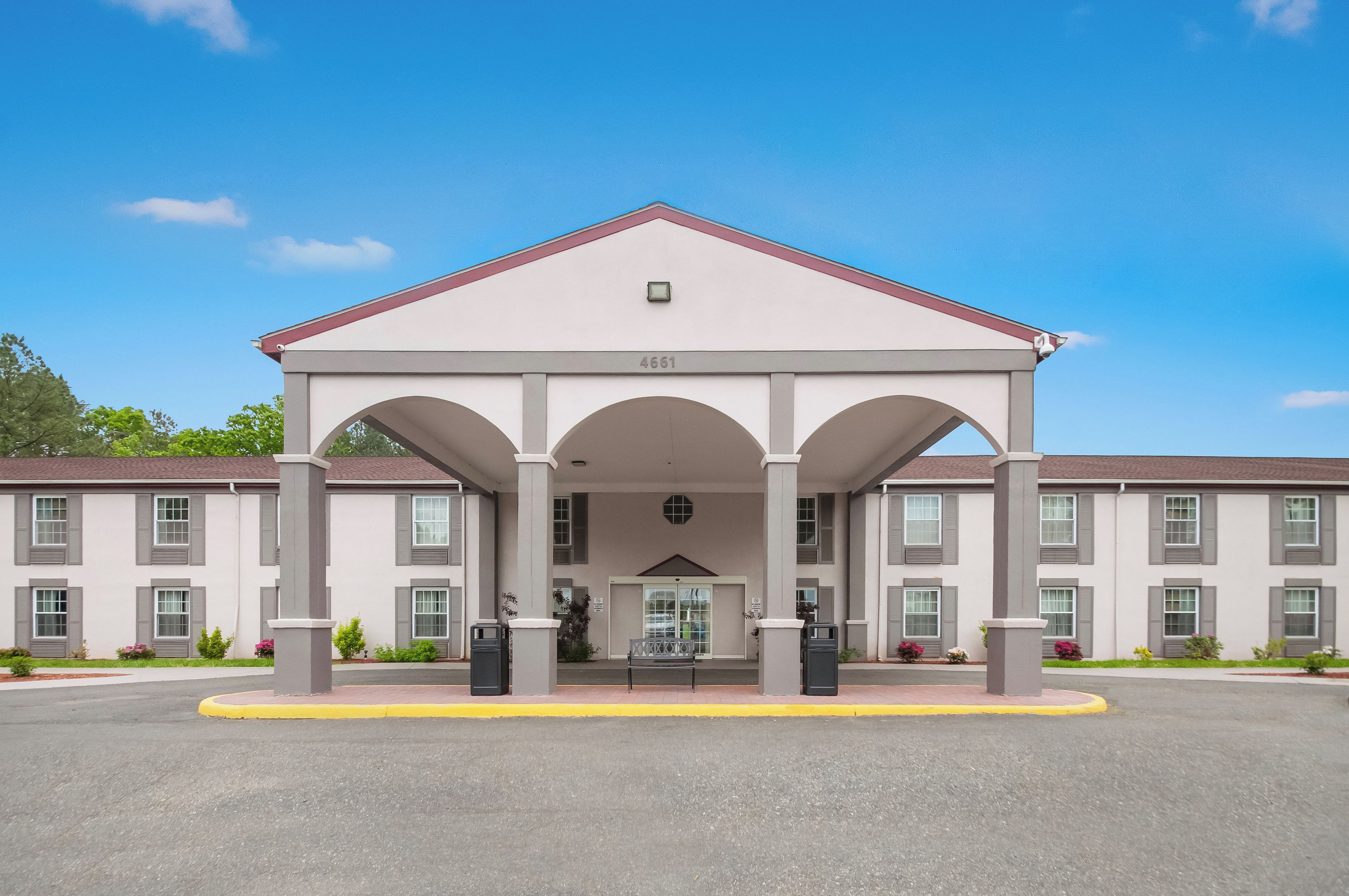 A two-story building with a central entrance, large windows, and a flat roof.