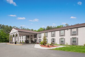 A multi-story building with a covered entrance and a landscaped front yard. - Red Roof Inn Dahlgren - Naval Base (King George)