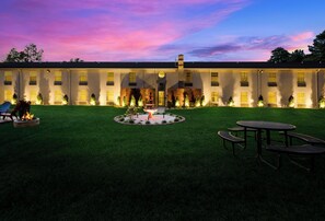 A building with a symmetrical facade, multiple windows, and a central courtyard with a fountain.