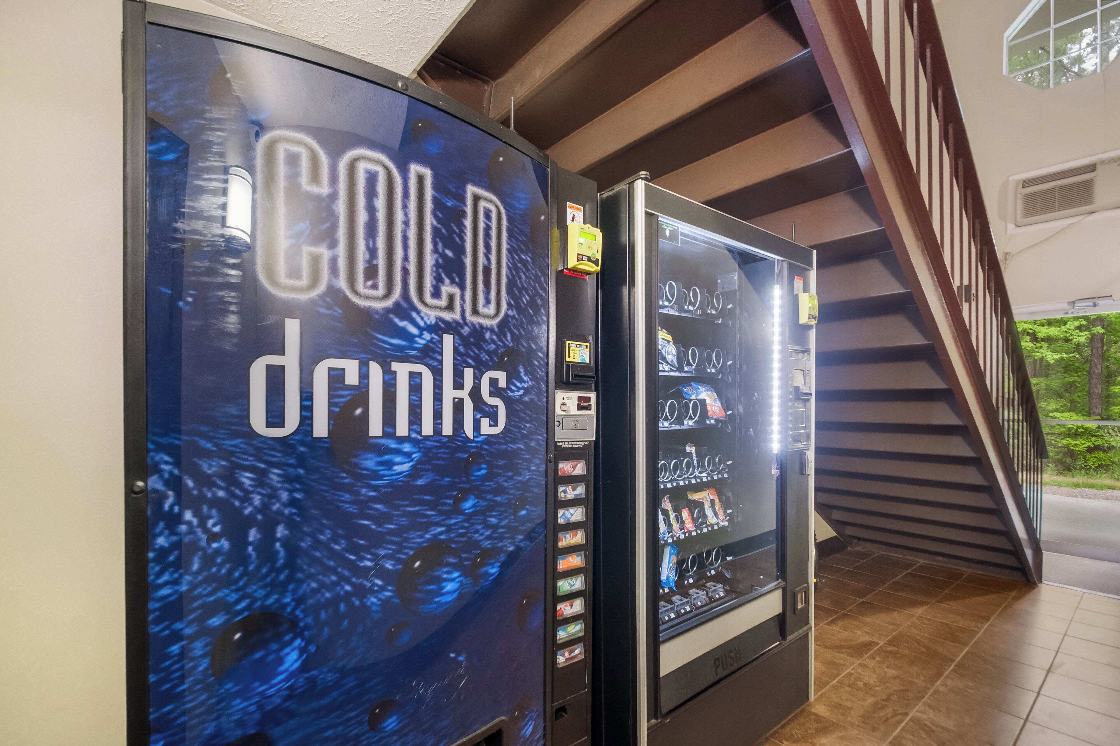 Dos máquinas expendedoras con la etiqueta 'COLD drinks' y una variedad de bebidas en su interior.