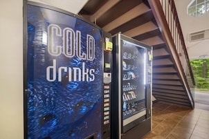 Dos máquinas expendedoras con la etiqueta 'COLD drinks' y una variedad de bebidas en su interior.