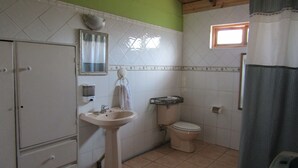 Ein Badezimmer mit Waschbecken, Toilette und einem kleinen Fenster.