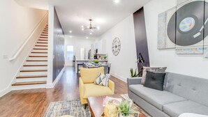 Ein modernes Wohnzimmer mit Treppe, Essbereich und Küche.