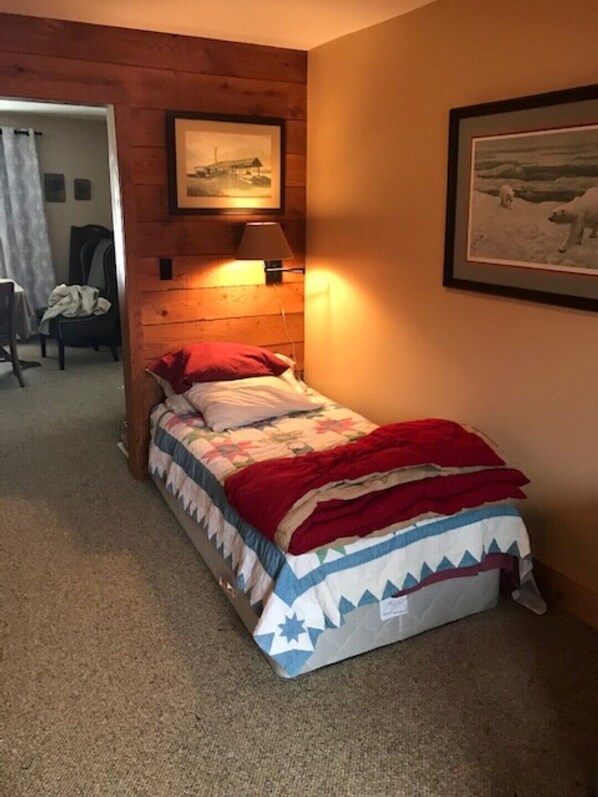 A single bed with a red and white quilt, a wooden headboard, a wall-mounted lamp, and a framed picture above the bed. - Westwood-Very Private - Blackwater Canyon Trail- 1 mile from Thomas (Thomas)
