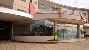 Un edificio moderno con fachada de vidrio curvada, una bandera roja y un letrero que dice 'Portal'.