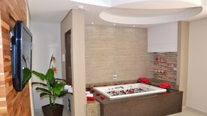 Un baño moderno con una bañera grande, una planta en maceta y un tocador de madera.