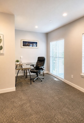 A room with a single black office chair, a small table with a potted plant, a framed picture on the wall, and a window with blinds. - Spacious Draper Retreat 3BR, Sleeps 8 - Near Snowbird (Draper)