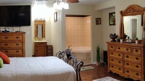 Ein Schlafzimmer mit einem Bett, einem Schminktisch, einer Kommode und einem Fernseher.