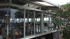 Ein modernes Gebäude mit großen Glasfenstern und einem überdachten Außenbereich.