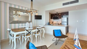 Una cocina moderna con televisor de pantalla plana, microondas y refrigerador.