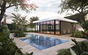 A modern house with a glass-enclosed patio, a swimming pool, and lush greenery. - CASA THULA - PRIVATE POOL  (Playa del Carmen)