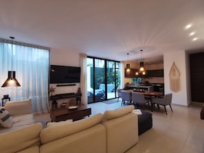 Relax in this spacious living area with a comfortable sofa, flat-screen TV, and dining table.