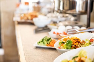 Una mesa de buffet con diversos platos, incluyendo ensaladas y otras opciones de comida.