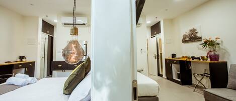 Une chambre d’hôtel moderne équipée d’un lit, d’un bureau, d’une chaise, d’une kitchenette et d’une salle de bain.