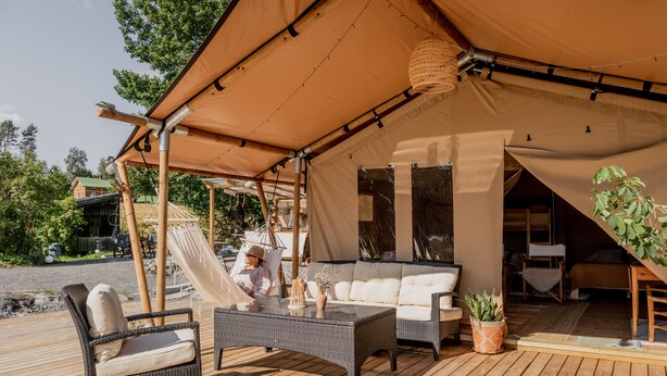 Un’area salotto esterna con mobili in vimini, un tettoia e vista sul paesaggio circostante.