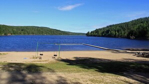 Una spiaggia sul lago con altalene e tavoli da picnic.