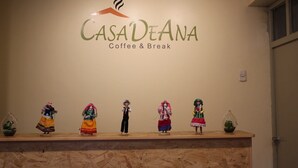 A wall with the sign "CASADEANA Coffee & Break" and a row of figurines on a counter. - Casa de Ana Huaraz (Independencia)