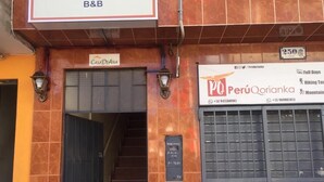 A building with a sign for 'CasaDeAna B&B' and another sign for 'PerúQorianka' with contact numbers. - Casa de Ana Huaraz (Independencia)