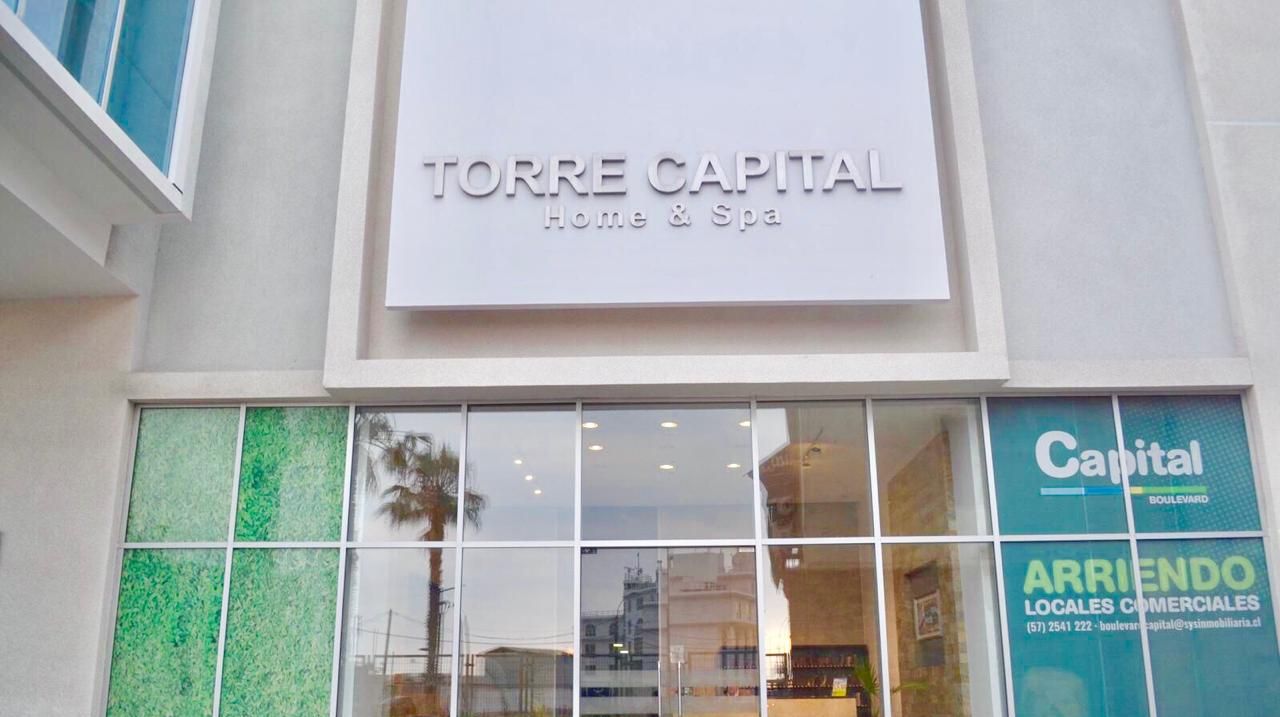 The exterior of TORRE CAPITAL Home & Spa with large glass windows and a signboard.