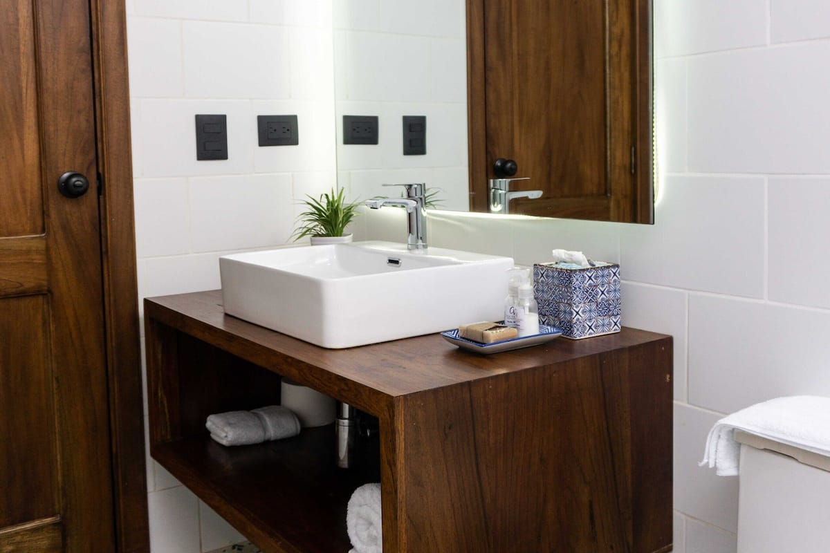 deluxe quadruple room | bathroom | hair dryer, towels, soap, shampoo