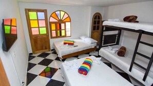Ein Hotelzimmer mit Schachbrettfußboden, zwei Betten, einem Etagenbett und einem farbenfrohen Streifenhandtuch.