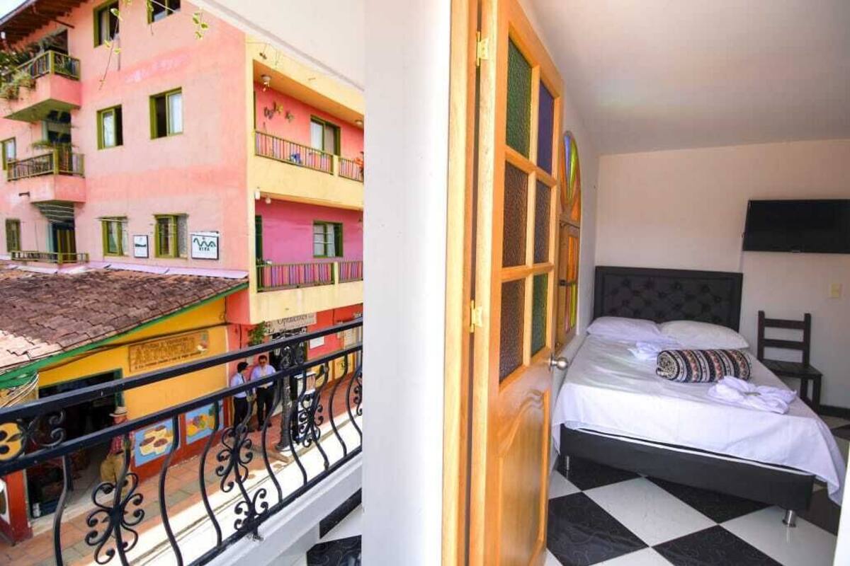 A room with a bed, a window, and a balcony with railings.