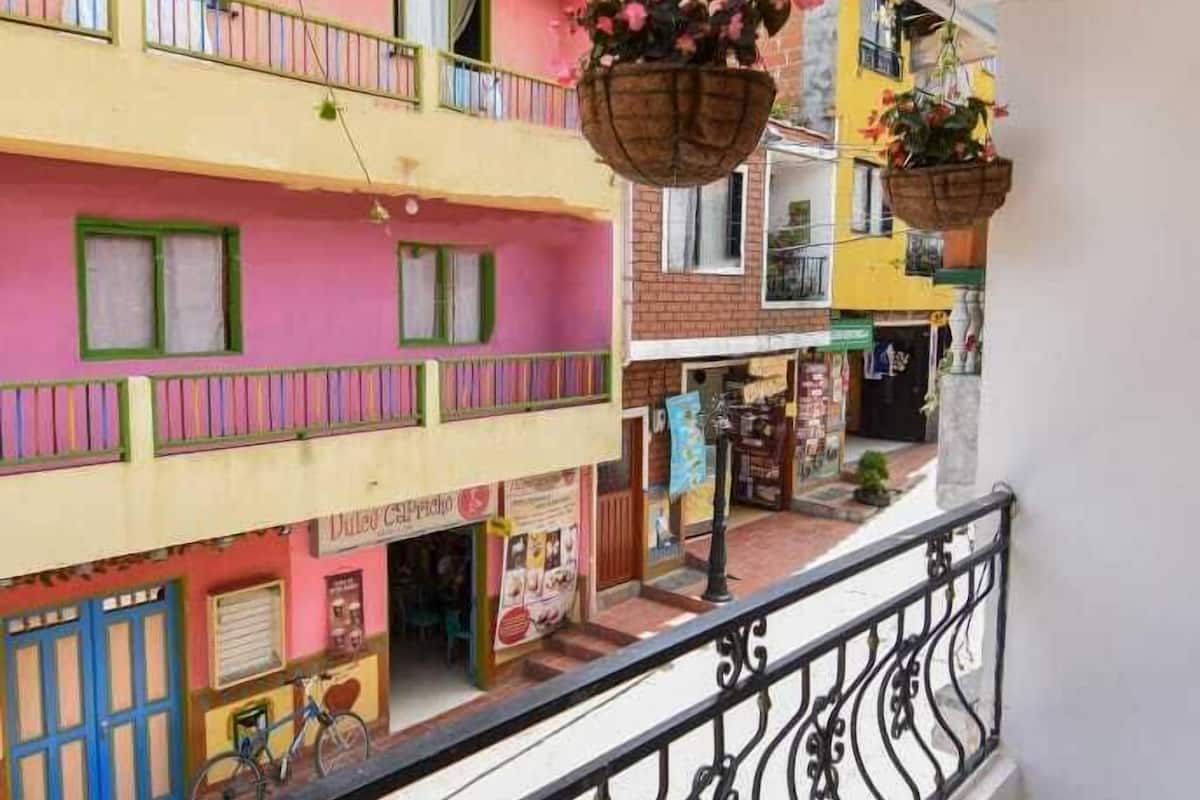 A multi-story building with balconies, a bicycle parked outside, and hanging flower baskets.