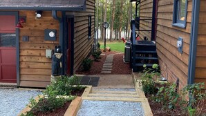 A wooden cabin with a gravel driveway and a small garden area. - Cedarwood Lake House (Toccoa)