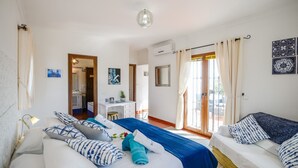 Ein Hotelzimmer mit Bett, Schreibtisch, Stuhl und einer Couch. Ein Fenster mit Vorhängen bietet einen Blick hinaus.