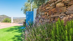 A stone wall with lavender plants in front of a blue tiled fence. - Villa Dajabe Sayalonga by Ruralidays (Málaga)