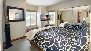 Une chambre avec un grand lit, une télévision et un miroir.
