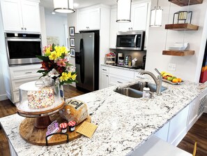 A modern kitchen with stainless steel appliances, a granite countertop, and a built-in oven. - Starlanding House: Downtown, Trails, Museums, Read the reviews- we'll spoil you! (Bentonville)