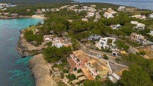 A coastal residential area with houses, a beach, and a clear view of the sea. - Ca Na Marieta House next to the beach with sea views and large garden (Portocolom)