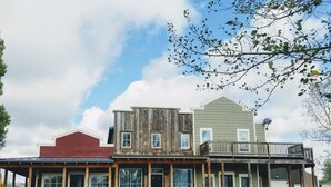 Un conjunto de edificios de tres pisos con un porche cubierto y un patio cercado.