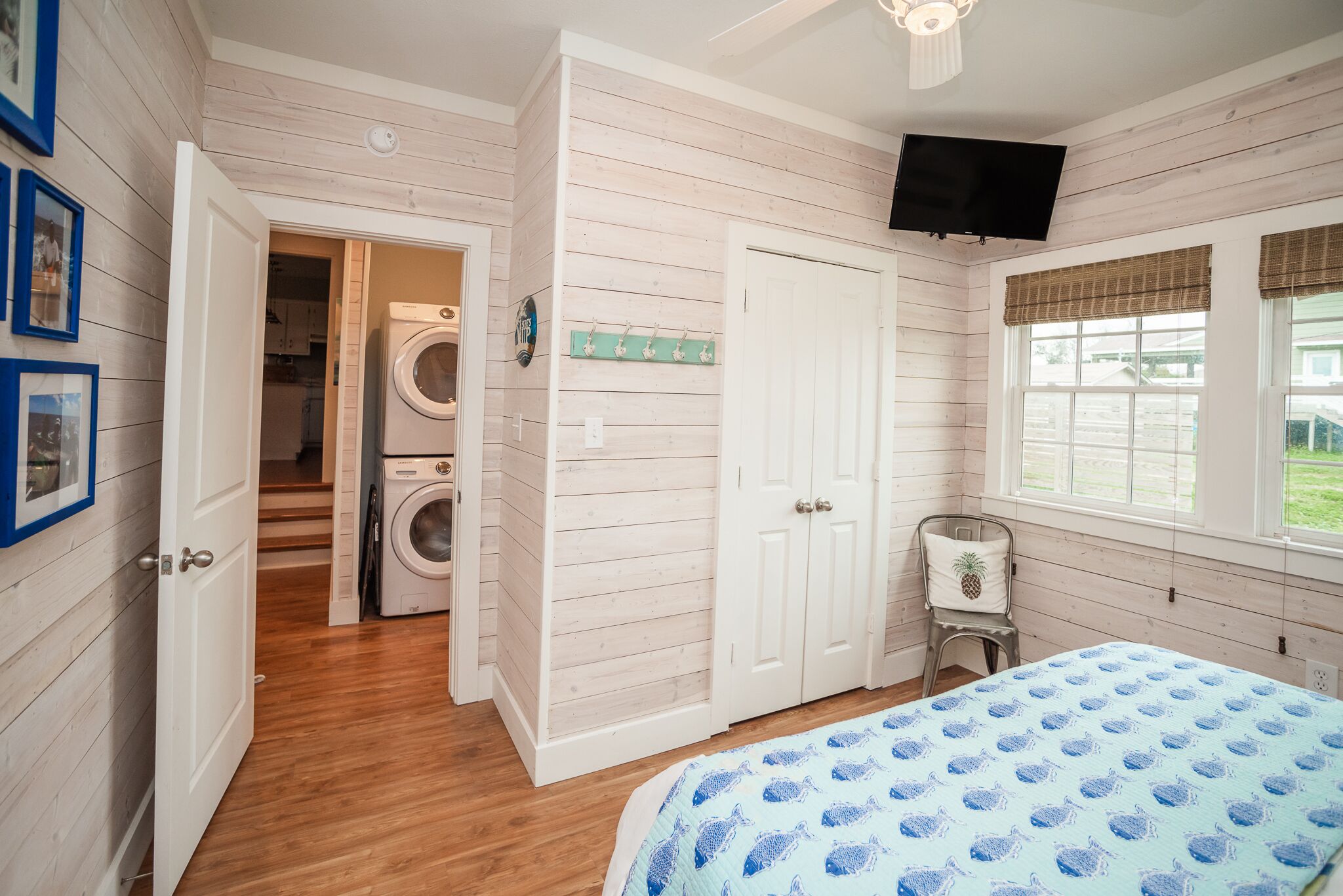 Une chambre à coucher avec un lit, un lave-linge, une télévision et une fenêtre donnant sur un beau paysage.