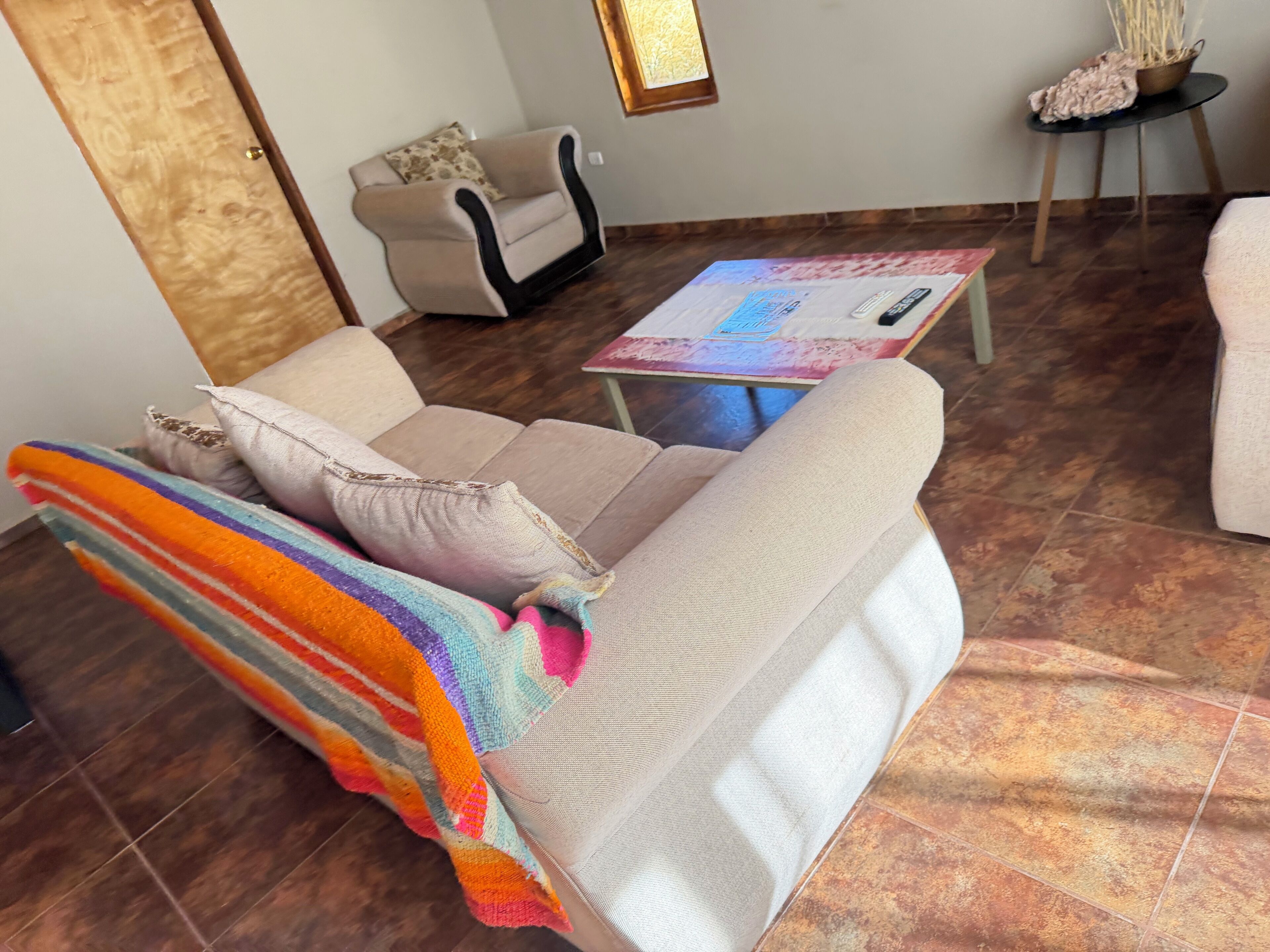 Un salon avec un canapé, une table basse et une petite table d’appoint.