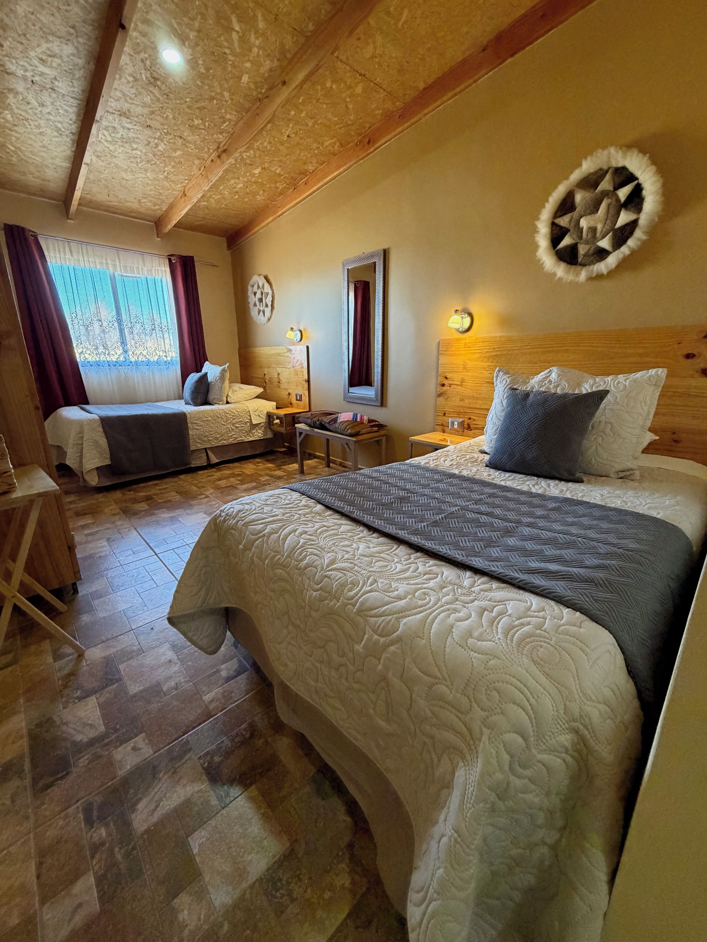 Een knus slaapkamer met een groot bed, een houten hoofdbord, een klein tafeltje en een nachtkastje.