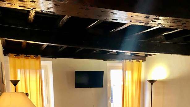Una habitación con una cama, un sofá, una mesa con una lámpara, un televisor y una silla.