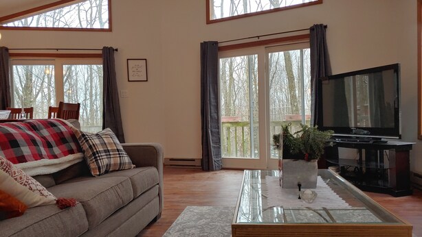A cozy living room with a sofa, a glass coffee table, and a television.